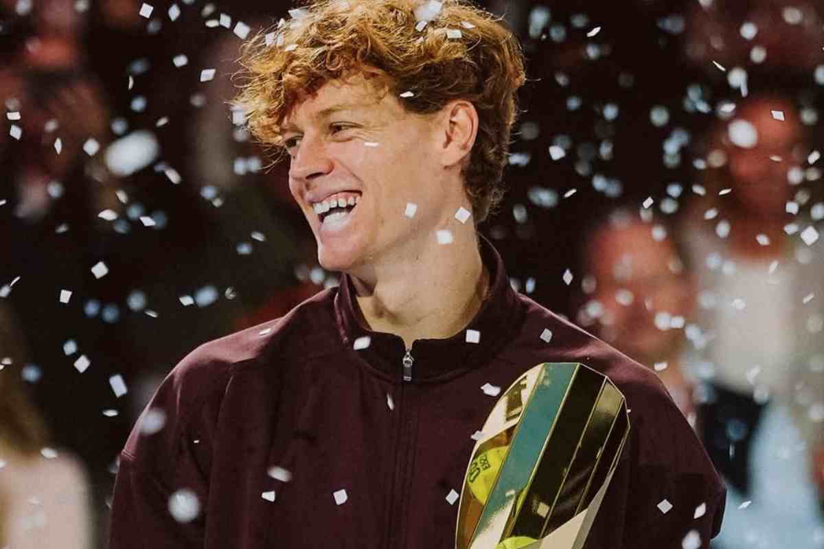 Jannik Sinner sorride con un trofeo in mano